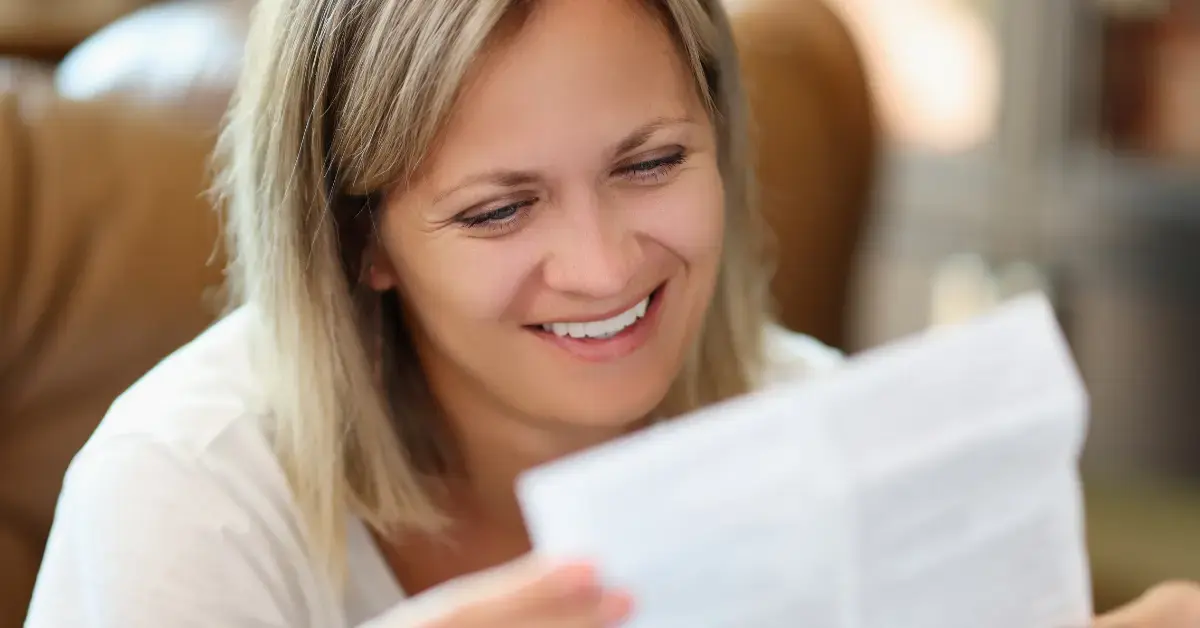 Eine lächelnde Frau liest eine Gebrauchsanweisung (IFU) für ein Medizinprodukt im Kontext der klinischen Bewertung.