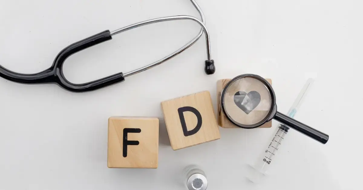 Holzbausteine mit der Aufschrift FDA neben einem Stethoskop zur Veranschaulichung der Anpassung von 21 CFR Part 820 (QMSR).