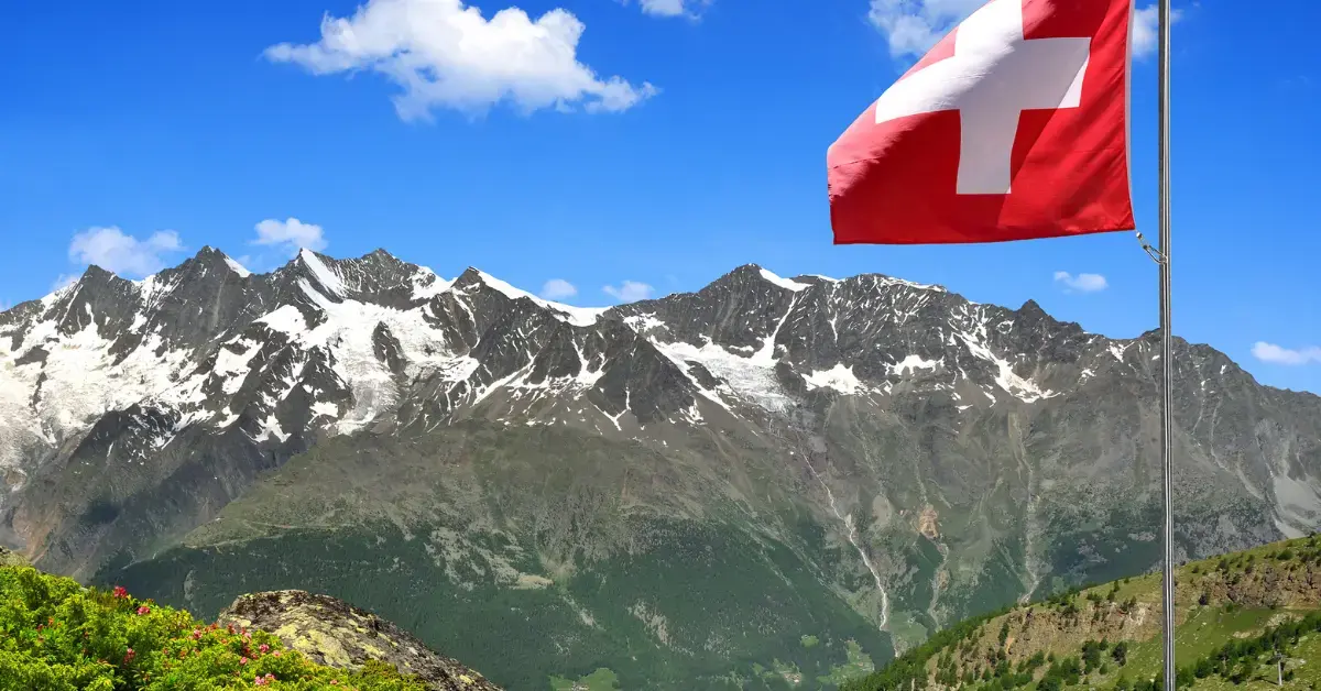 Schweizer Flagge vor einer Alpenlandschaft als Symbol für die neue Schweizer Regulierung von In-vitro-Diagnostika (IvDV), regulatorische Anforderungen und Marktzugang für Medizinprodukte.