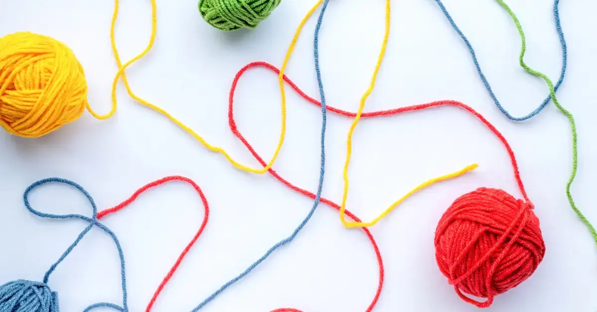 Bunte Garnfäden mit verschiedenen Verbindungen als Symbol für Rückverfolgbarkeit, Verifizierung, Validierung und strukturierte Prozesse in der Entwicklung und Qualitätssicherung von Medizinprodukten.