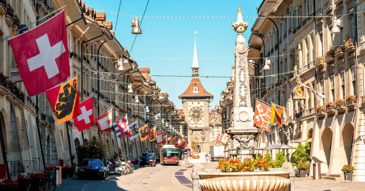 Historische Altstadt von Bern mit Schweizer Flaggen und dem Zytglogge-Turm – Symbol für die Schweizer Medizintechnikbranche und regulatorische Anforderungen im Gesundheitswesen.