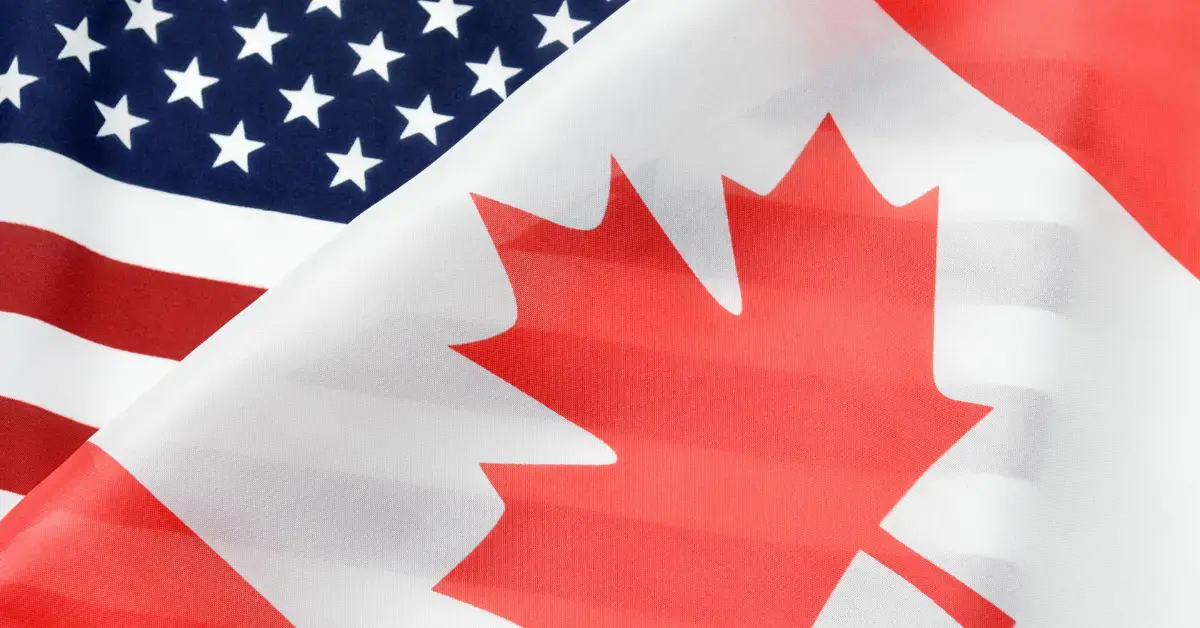 Nahaufnahme der Flaggen von Kanada und den USA als Symbol für nordamerikanische Handelsbeziehungen, internationale Zusammenarbeit und regulatorische Anforderungen im grenzüberschreitenden Markt.